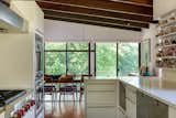 The bright kitchen connects to the dining area. Billinkoff designed the custom kitchen cabinets, which include removable shelves that house the couple’s teacup collection, with pre-finished maple and plastic laminate fronts. The countertops are Corian.&nbsp;