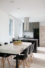 Sonja designed the dining room table using three solid fir beams that were treated by local craftsmen and set on top of a black steel base. The countertops are made of a composite laminate that has the texture and shade of weathered wood.