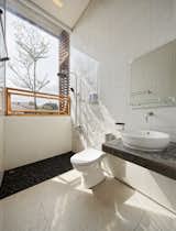 The upper-level bathroom has an indoor/outdoor feel. A pull-down shade provides privacy when needed.