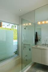 The master bathroom boasts a step-down terrazzo bathtub and a peek-a-boo view of the pool area.&nbsp;