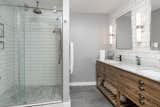 The bathroom features white subway tile and a double vanity.
