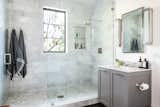 The bath also features a spacious glass-enclosed, marble-tiled shower.&nbsp;