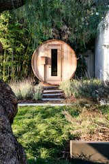 Outside, a barrel-shaped sauna offers sits below swaying bamboo trees.