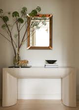 A lovely hallway vignette consists of a Karl Springer console and a mirror from Fontana Arte.&nbsp;