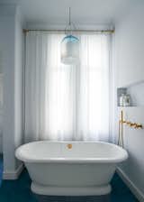 A blown glass and chrome pendant light by Carlo Nason for Mazzega hangs above the soaking tub.&nbsp;