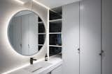 The master bathroom also has ample storage and a large, circular mirror. 
