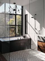 The master bathroom features cement Cigar Shop tiles by Clé Tile. The tub is made of black-honed absolute granite with plumbing ﬁxtures by Dornbracht. The lighting is the Double Octopus by Autoban for De La Espada. 
