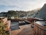 The dreamy rooftop looks out over Noe Valley. Built-in redwood benches surround a concrete ﬁre pit; the bluestone pavers are part of a Bison deck system. An oversize, barrel-like teak hot tub from Roberts Hot Tubs allows for a soak in the garden-like setting, which features plants selected and installed by Danielle Coulter of Collecting Flowers. 