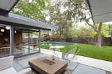 The backyard has an expansive lawn, mature trees, plenty of patio space, and a kidney-shaped pool.