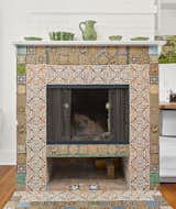 In the kitchen, a rustic fireplace is framed by colorful patterned tiles.