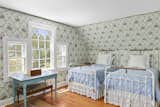 Another bedroom features a Palladium window and enough room for two twin beds. The floral wallpaper may even be original.