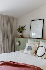 The master bedroom features a scalloped, light green headboard lined in Porta timber moldings. 