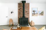 Interior designer Natalie Myers fixed up a 1958 Yucca Valley cabin that had fallen prey to a house flipper’s uninspired renovation.&nbsp;In the living room, a Franklin stove adds an authentic touch to the updated home. 