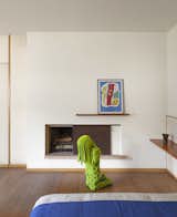 Simonsson's "Praying Moss Girl" is displayed in the bedroom against elegant shelving and a sleek slide away fireplace.&nbsp;