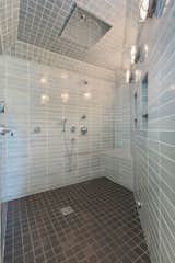 The spacious master shower is wrapped in light grey tiles.&nbsp;