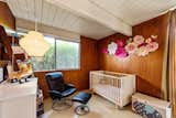 The third bedroom is currently the child's room. It also has the original wood paneled walls and features a Nelson pear wall sconce.&nbsp;