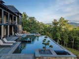 The pool deck is centered around an infinity pool with a hot tub that overlooks the spectacular scenery surrounding this resort-like residence.  Photo 3 of 9 in This North Carolina Hillside Home Offers Indoor/Outdoor Living with a Resort-Like Vibe