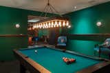 The new lower-level expansion provides an entertainment area that features a chic jewel-toned bar, billiards room, theater screening room, and private art gallery. Artwork and artifacts from the homeowner’s travels are displayed throughout the residence.