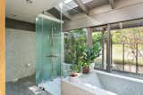 Clad in mosaic tile, the bathtub and shower feel open to the outdoors.&nbsp;