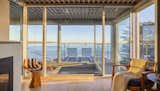 The primary bedroom has a fireplace and a floating walkway leading to a private balcony that appears to hover above the ocean. 