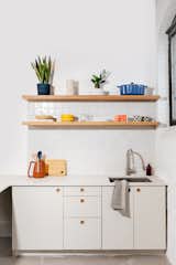The kitchen features cabinetry from Danish firm, Reform which give the space an apartment-like vibe. Ceramics for sale in the kitchen include yellow pasta bowls by Domenic Frunzi and the standout checkered every day mugs by local artist Athena Witscher.