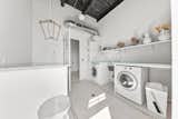 The laundry room features tile flooring and abundant storage options.&nbsp;