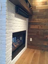 Double-sided fireplace, reclaimed wood mantle and wall