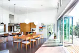 Mid-Century meets biophilic design in this Brentwood, Tennessee residence. The open concept dining area opens up to the expansive deck outside with the help of a NanaWall folding glass wall. When closed, the minimal frames of this glass system are barely visible, perfectly framing the green mountain views outside and providing enough natural light to illuminate the entire area.