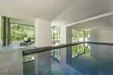 With design inspiration deriving from biophilic principles, this NanaWall minimal sliding glass wall transforms the space into an indoor/outdoor pool.  The expanse of the sliding glass panels mimic the grandeur of the massive pool inside as well as the minimalist vibe of the architecture.