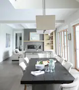 This inviting British Columbia home boasts an open concept floor plan softened by natural accents. Earthy tones envelop the walls and furniture while wooden accents enhance the farmhouse appeal—from the dining table to the NanaWall folding glass wall featuring the warmth and beauty of wood with a durable powder coat on the exterior for less maintenance.