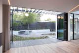This giant bi-fold door opens up to a covered boardwalk-style walkway and the backyard.