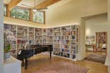 The most personal space in the house is the library/piano practice space that is open to the great room. Hundreds of books line three walls that embrace a concert grand that Laurie plays daily, much to the delight of her border collie puppy, Emma. Unlike the large expanses of glass elsewhere in the house, the space is softly lit by three trapezoidal windows placed under the sloping roof, protecting Laurie’s treasured heirlooms and travel mementos from direct sunlight while offering a view of the sky from the piano bench.