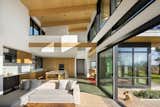 View of great room from living area to kitchen and dining areas, with loft office above
