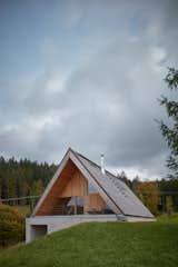 Exterior, Concrete Siding Material, Wood Siding Material, Gable RoofLine, and House Building Type  Photo 3 of 23 in This Mountain Hideaway in the Czech Republic Burrows Into a Meadow from Weekend House in Beskydy