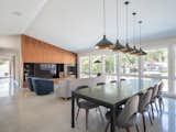 Dining Room, Ceiling Lighting, Wood Burning Fireplace, Concrete Floor, Pendant Lighting, Table, and Chair Open Kitchen + Dining + Living  Photo 6 of 18 in Homestead Residence by KEM STUDIO