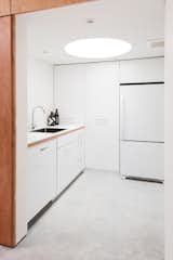 The kitchen has a low ceiling with an inset circular skylight that creates a tubular glow.