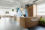 The entrance to Werklab features a custom cork-panel concierge and a hanging glass partition by Yuli Glass—who create permanent glass art using ceramic pigments, tempered glass, and industrial kiln firing in a patent-pending process.