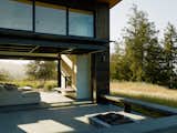 Outdoor, Side Yard, Shrubs, Concrete Patio, Porch, Deck, and Large Patio, Porch, Deck The expansive Northern Californian landscape seamlessly enters the home.  Photo 9 of 10 in Four Enormous Glass Doors Turn This Northern California Home Into an Outdoor Pavilion