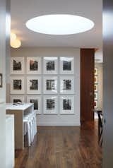 This photo shows the transition between the entry hallway and the kitchen & dining areas.  The drum skylight in the ceiling above illuminates the space with natural daylight.