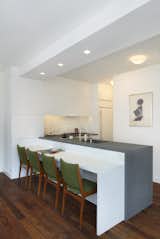 A three-quarter view of the kitchen and breakfast area.  The lower seating area countertop is Glacier White Corian and the upper counter is Atlantic Bluestone.  The chairs are vintage and reupholstered in Brushed Merino Sprig by Maharam.