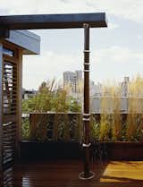 Water flows from the collection trough in the inverted roof down the outside of a steel pipe and over adjustable zinc plated collars.  The adjustable collars were designed to allow the owner to create different patterns of falling water when it rains.  Photo 2 of 9 in East Village Penthouse & Roof Garden by pulltab