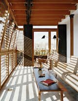 Sunlight filters through the teak brise-soleil.  Waxed blackened steel panels complement the woodwork and the travertine floor.