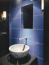 Powder Room commands attention with its marine blue glass tile wall.