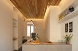 Fluorescent lighting hanging over the plinth-like counter and concealed behind the lowered ceiling.