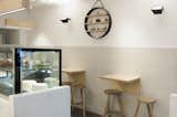 Tiles to the walls and vinyl to the floor are both continuous between the customer and staff areas, further blurring the boundary between the two and heightening the sense of involvement in the baking process.