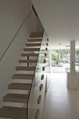 The modern lower-ground floor connects to the rest of the house via an open-riser timber staircase with clear glass balustrade.