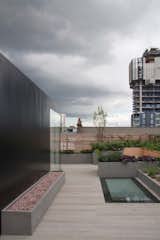 The new-build pavilion is clad in black panels, black-backed glass, and black warehouse-style windows.