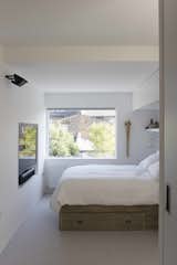 The frameless window of the rear first-floor bedroom presents the neighboring original building stock as if it were a painting or photograph on the wall.