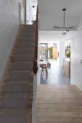 Hallway and Light Hardwood Floor The view from the front door allows the rear bedroom to the modern first floor to be seen together with the rear extension to the ground floor, of which it is architecturally a satellite component.  Photo 6 of 13 in Proun House by WILLIAM TOZER Associates