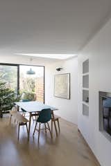 Viewed from the living area of the open-plan space, the dining area is visually defined by a crank in the floor-plan and a triangular roof-light, which punctuates this reorientation on the ceiling plane.